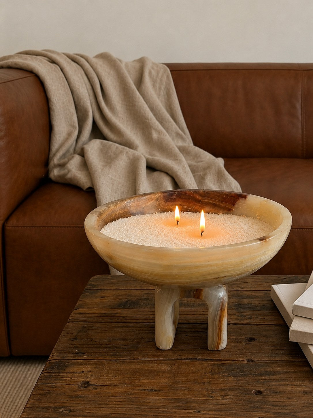 The Onyx Arched Refillable Candle Set, lit, on a coffee table